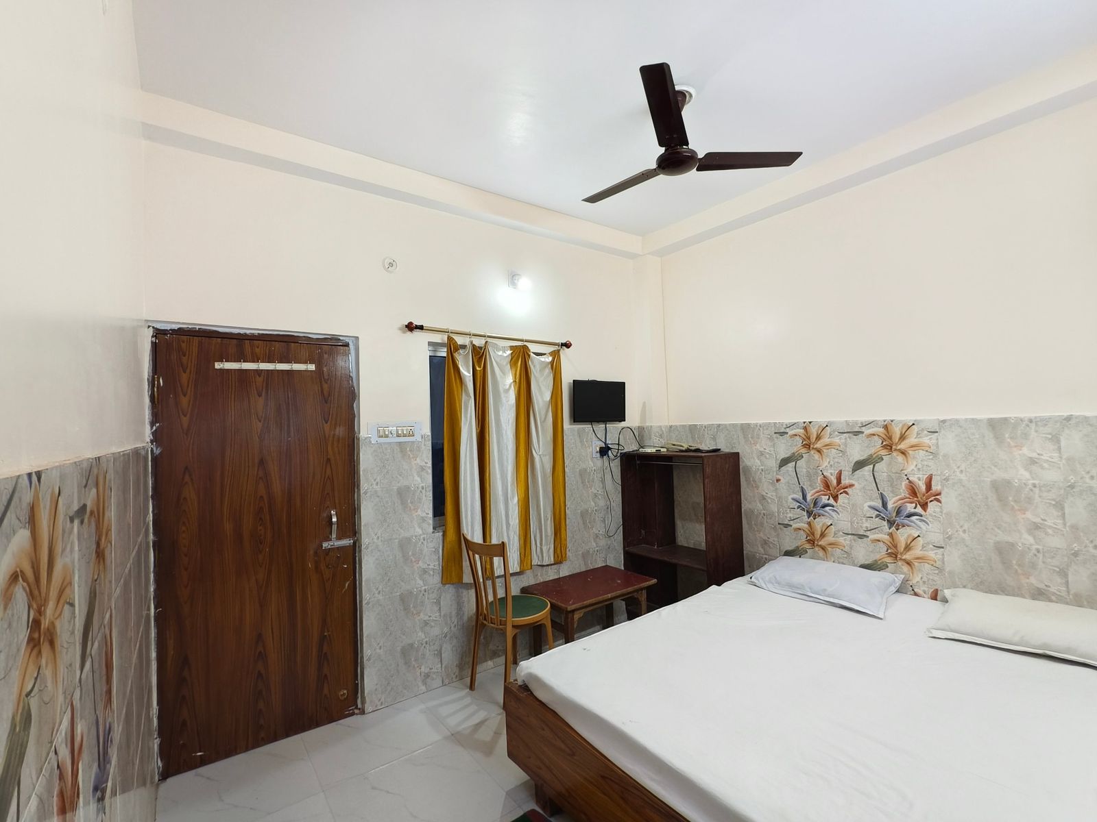 Guest room with double bed, wardrobe and wall tiles at Hotel Vijay, Rajgir